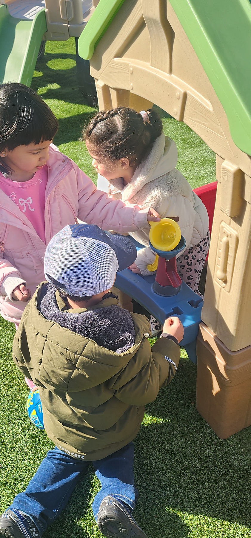 Children playing together at the outdoor playhouse
